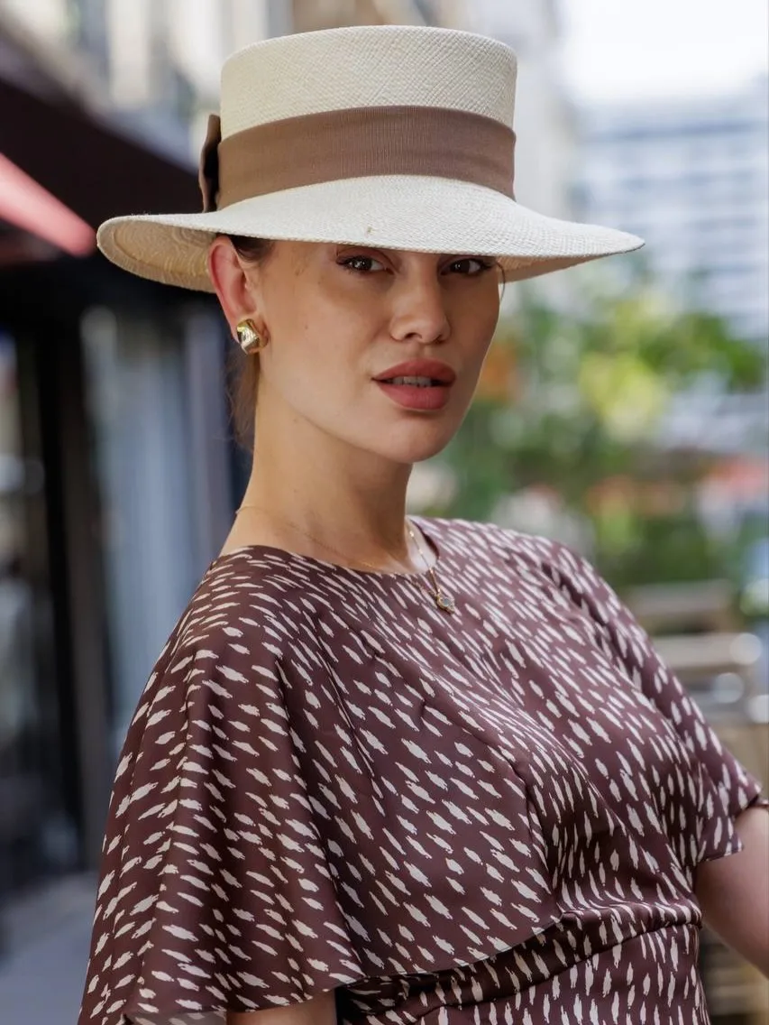 Close portrait under the straw boater with a wide taupe band and gold earrings