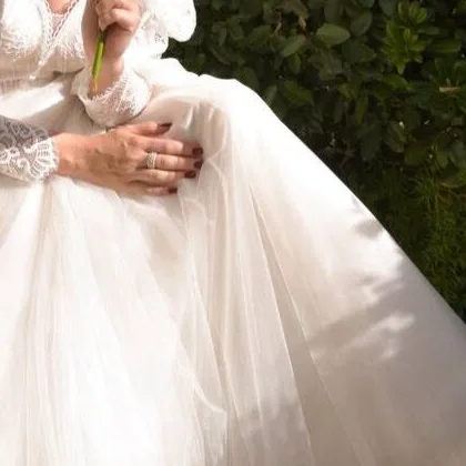 Hands resting on ivory tulle, lace cuff detail
