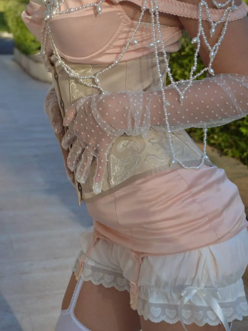 Back view of the brocade corset, blush satin slip and lace bloomers with polka-dot tulle opera gloves