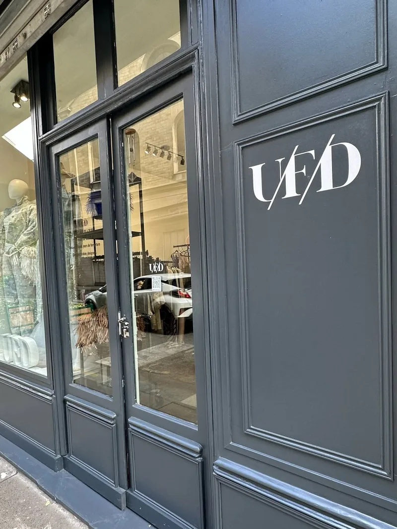 Angled view of the charcoal UFD shopfront with a mannequin in the window and white UFD letters on display